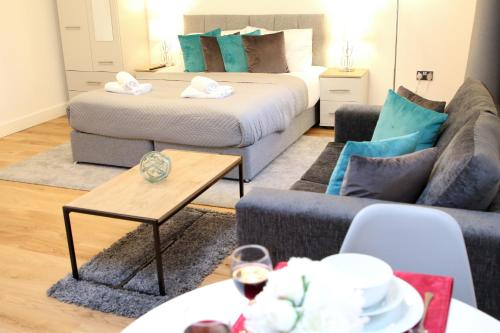 uma sala de estar com um sofá e uma cama em High Spec Luxury Studio Apartment in Sydenham em Sydenham
