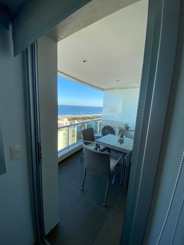 a dining room with a table and a view of the ocean at Wind Tower Punta del Este in Punta del Este