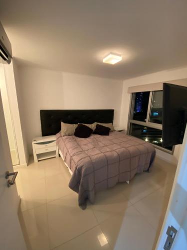 a bedroom with a bed and a flat screen tv at Wind Tower Punta del Este in Punta del Este