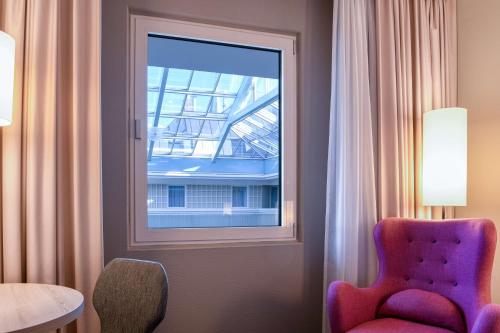 a room with a lamp and a window at Radisson Blu Hotel Bremen in Bremen
