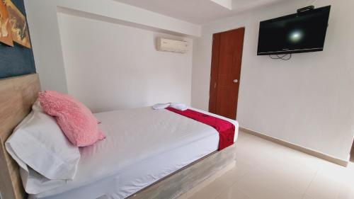 a small white room with a bed and a flat screen tv at Magdalena Imperial Hotel By GHO Hoteles in Girardot