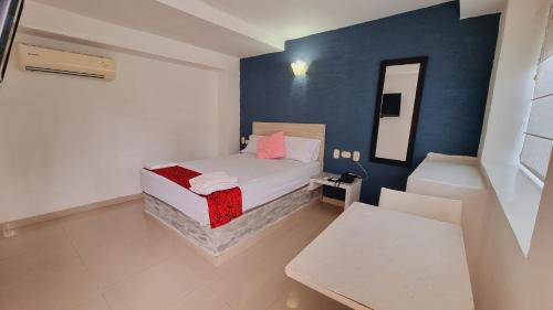 a small bedroom with a bed and a mirror at Magdalena Imperial Hotel By GHO Hoteles in Girardot