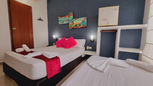 two beds in a small room with blue walls at Magdalena Imperial Hotel By GHO Hoteles in Girardot