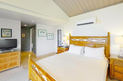a bedroom with a large bed and a television at Hanalei Bay Resort 7301 in Princeville