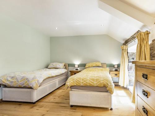 a bedroom with two beds and a dresser at The Hayloft in Whaley Bridge