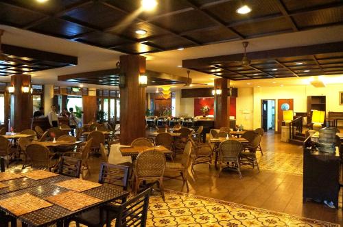 a restaurant with tables and chairs in a room at Kampung Sumber Alam Garut in Garut
