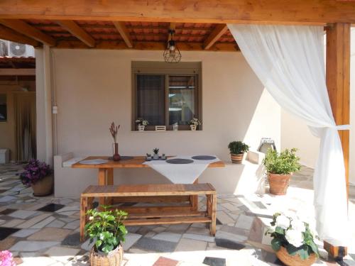 d'une terrasse avec une table et un banc. dans l'établissement Psaromoura Apartment, à Agia Pelagia