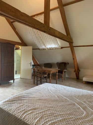 a bedroom with a bed and a table and chairs at Welkom huis in Eecke