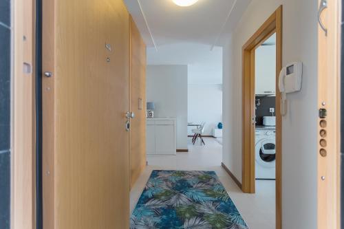 a hallway with a door and a rug on the floor at Pôr do Sol in Nazaré