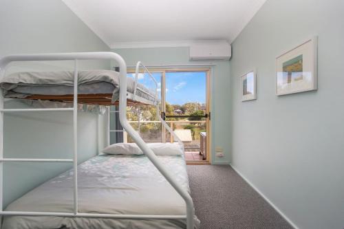 a bedroom with bunk beds in a room with a window at Beach Haven in Hawks Nest