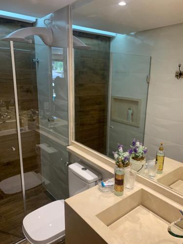 y baño con ducha, aseo y lavamanos. en Flat Life Resort com vista pra piscina/lago, en Brasilia
