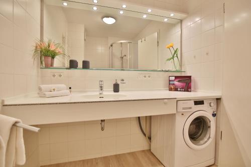 een badkamer met een wastafel en een wasmachine bij Strandduene Stranddüne Appartement 3 in Haffkrug