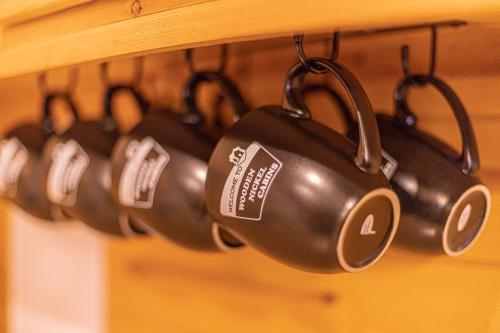 a bunch of coffee cups hanging from a rack at Cabin #4 The Wolves Den - Pet Friendly- Sleeps 6 - Playground & Game Room in Payson