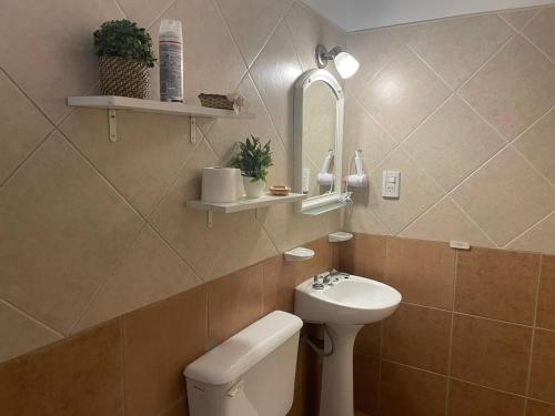 a bathroom with a sink and a toilet and a mirror at Confortable cercanía in San Juan