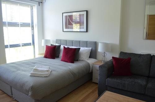 a bedroom with a bed and a couch at Executive Bright and Airy Studio Apartment in Sydenham in London