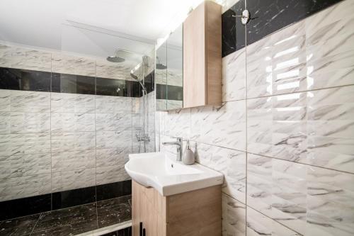 a bathroom with a sink and a glass shower at En Elladi Apartment in Alikanas