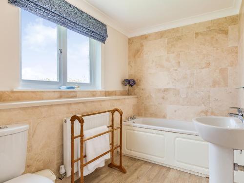 Un baño con bañera, lavabo e inodoro. en Penhallick House, en Tintagel