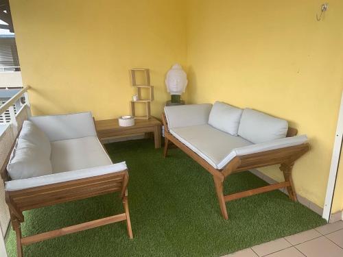 two chairs and a couch in a room at The N’house in Kourou