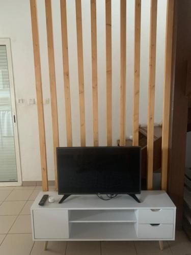 a flat screen tv sitting on top of a white cabinet at The N’house in Kourou