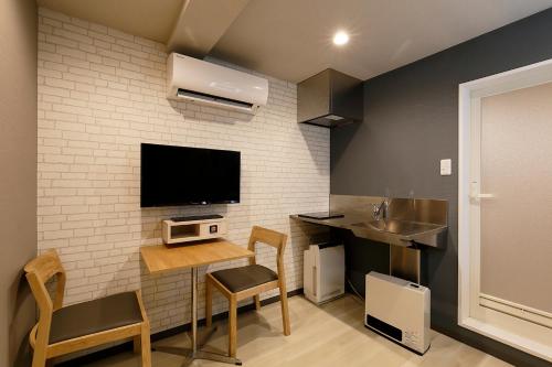 a living room with a table and a tv on a wall at 555 MOTEL GOTEMBA in Gotemba