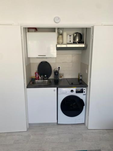 Il comprend une petite cuisine équipée d'un évier et d'un lave-vaisselle. dans l'établissement Studio cosy entièrement équipé, à Nice