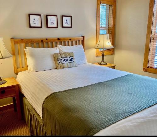 a bedroom with a large bed with two lamps and two pictures on the wall at Lighthouse Inn in Cannon Beach