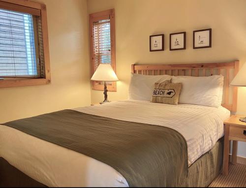 a bedroom with a large bed and two windows at Lighthouse Inn in Cannon Beach