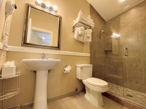 a bathroom with a toilet and a sink and a shower at Lighthouse Inn in Cannon Beach