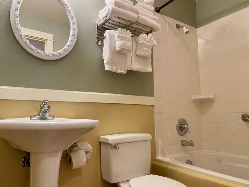 a bathroom with a sink and a toilet and a mirror at Lighthouse Inn in Cannon Beach