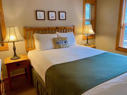 a bedroom with a large bed with two lamps at Lighthouse Inn in Cannon Beach