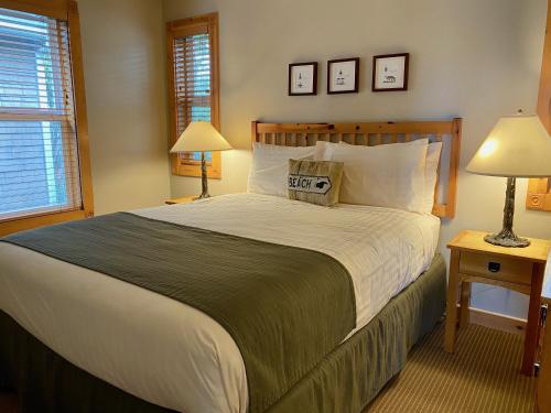a bedroom with a large bed and two lamps at Lighthouse Inn in Cannon Beach