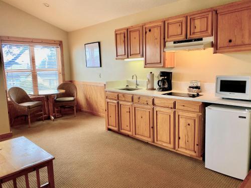 a kitchen with wooden cabinets and a white refrigerator at Lighthouse Inn in Cannon Beach