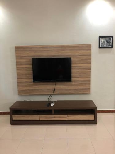 un soggiorno con una TV a schermo piatto su una parete di Crown Imperial Court Apt at Brinchang Centre a Brinchang