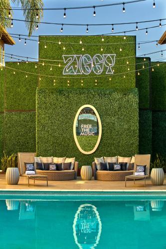 a pool with couches next to a wall with lights at Hotel Ziggy On Sunset in Los Angeles