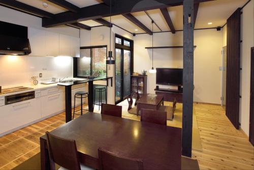 a kitchen and dining room with a table in a room at Kyoto Guesthouse Roujiya in Kyoto