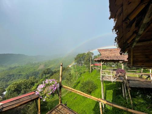 a view of a hill with a house and flowers at Ban Chomdoi Resort PhaTang in Ban Pha Tang