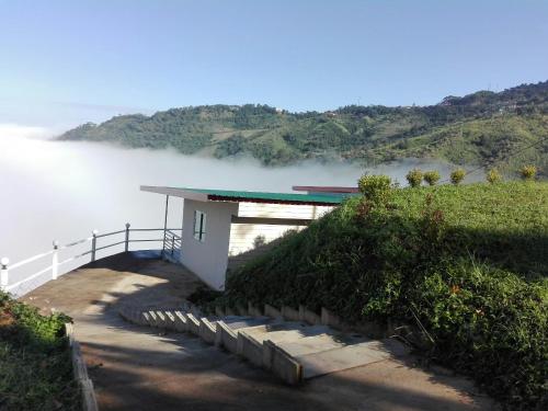 a building on a hill next to a body of water at Ban Chomdoi Resort PhaTang in Ban Pha Tang