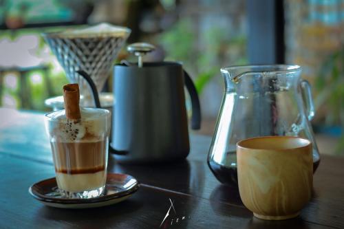 a wooden table with two cups of coffee and a tea pot at Ban Chomdoi Resort PhaTang in Ban Pha Tang