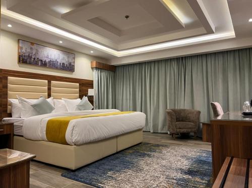 Pokój hotelowy z łóżkiem i krzesłem w obiekcie Moments Hotel w mieście Dżudda
