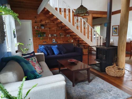 a living room with a couch and a stove at Spotted Gum Retreat at Mystery Bay in Mystery Bay
