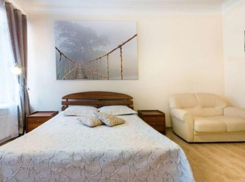 a bedroom with a bed and a bridge painting on the wall at Home Center Kiev Apartments in Kyiv