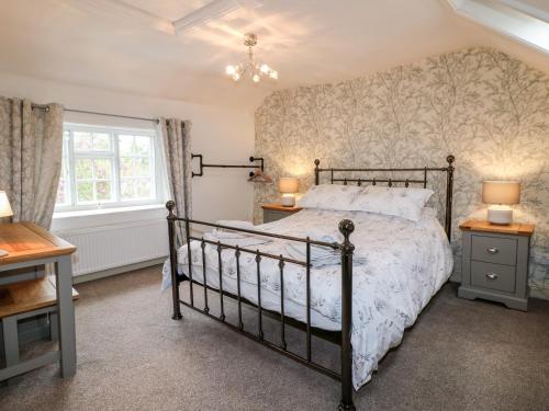 a bedroom with a bed and two lamps and a window at Christmas Cottage in Alfreton