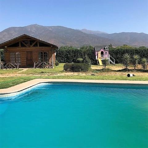 a large pool of blue water in front of a house at Gran Parcela Monte de Olmue in Olmué