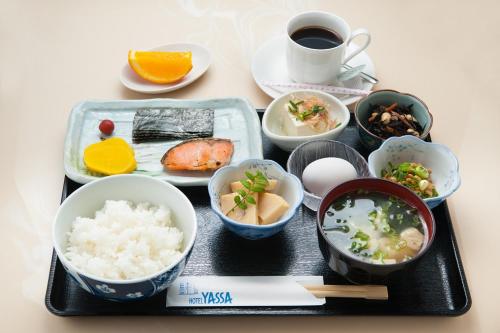 a tray with bowls of food and a cup of coffee at Hotel Yassa in Mihara