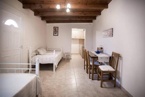 a bedroom with a bed and a table and chairs at Elleana south Corfu in Agios Georgios