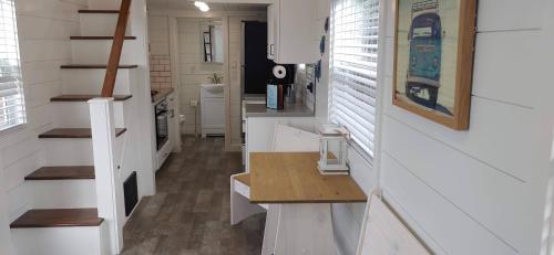 a kitchen with white counters and stairs in a tiny house at Pacific Dunes Resort in Copalis Beach