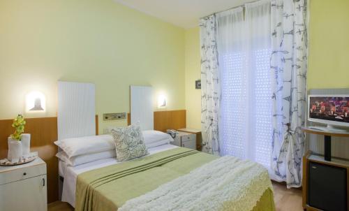 1 dormitorio con 1 cama y TV en Hotel Bel Air, en Riccione