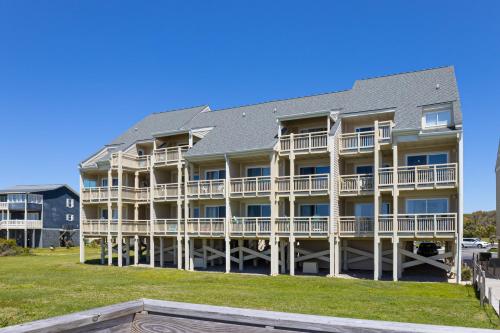 a large apartment building with balconies and a yard at CAB02 Three Brothers in Oak Island