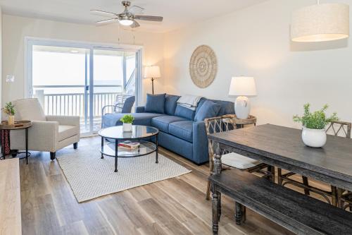 a living room with a blue couch and a table at CAB02 Three Brothers in Oak Island