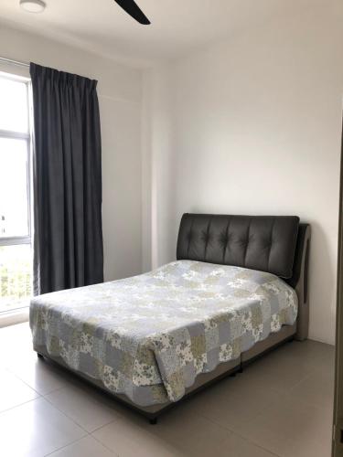 a bed sitting in a room with azeb at Barrington Square 2 Rooms Apartment at Golden Hill Night Market in Brinchang